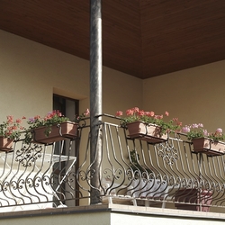 Garde-corps forg� sur le balcon d'une maison individuelle avec supports pour pots de fleurs